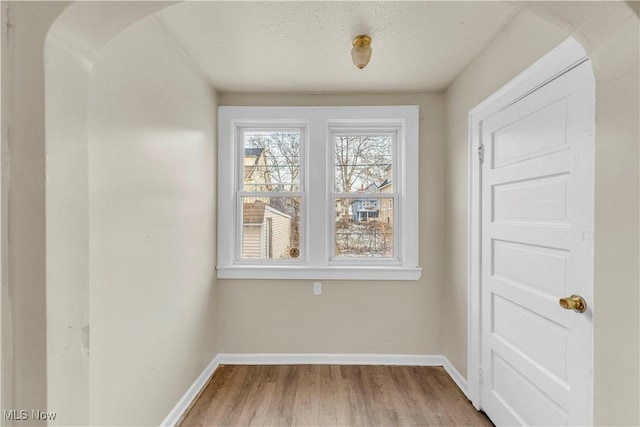 spare room featuring a textured ceiling and light hardwood / wood-style floors