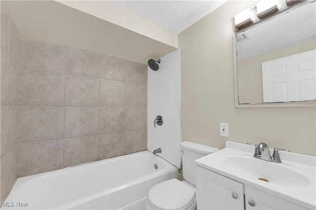 full bathroom with vanity, tiled shower / bath, a textured ceiling, and toilet