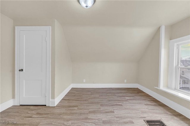 bonus room with lofted ceiling and light hardwood / wood-style floors