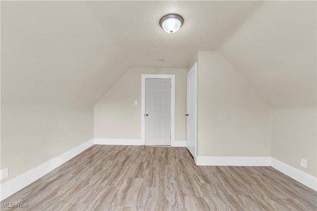 additional living space with lofted ceiling and light wood-type flooring