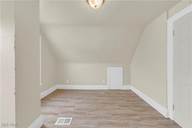 additional living space featuring lofted ceiling and light hardwood / wood-style flooring