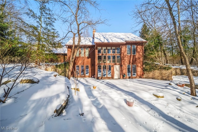 view of snow covered back of property