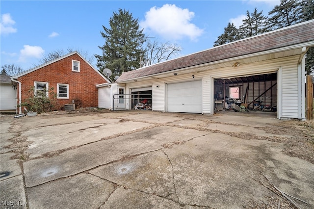 view of side of home featuring a garage, an outbuilding, and central AC unit