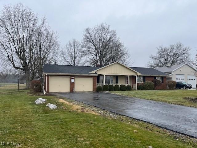 single story home featuring a garage, a front yard, and a porch