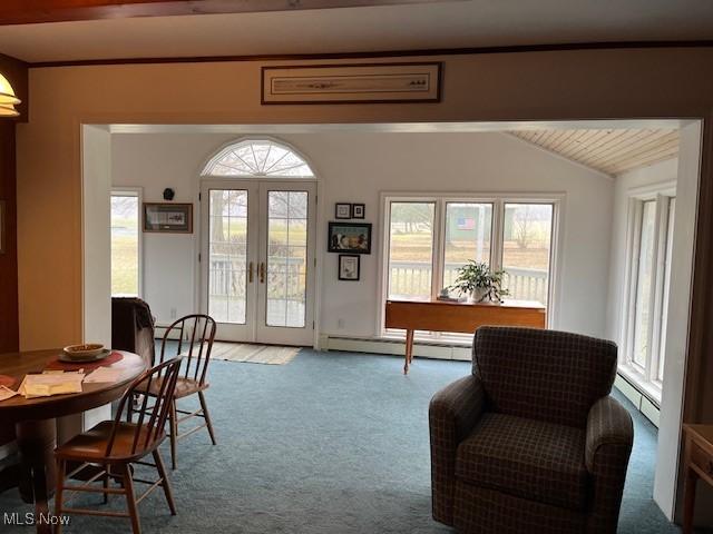 living area featuring vaulted ceiling with beams, light colored carpet, baseboard heating, and french doors