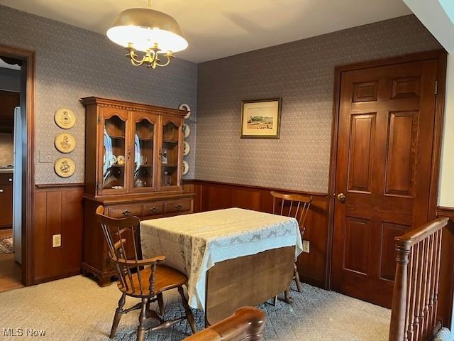 dining space featuring an inviting chandelier and light carpet