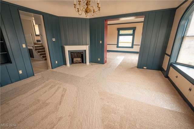 unfurnished living room featuring light carpet and a notable chandelier