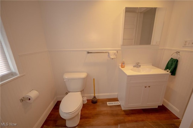 bathroom featuring wood-type flooring, vanity, and toilet