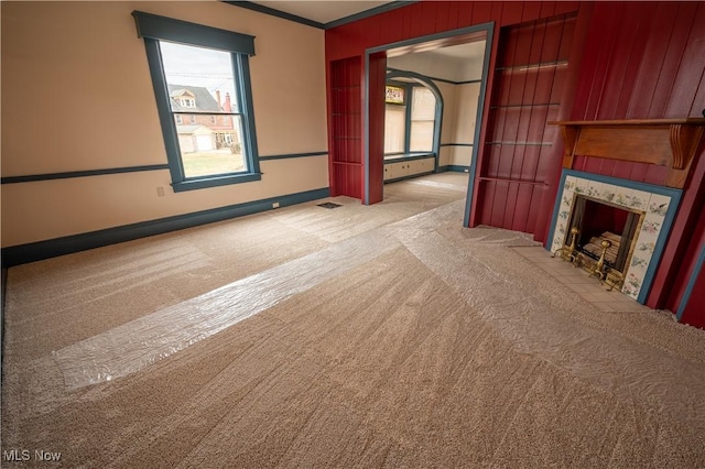 unfurnished living room with light colored carpet and a fireplace