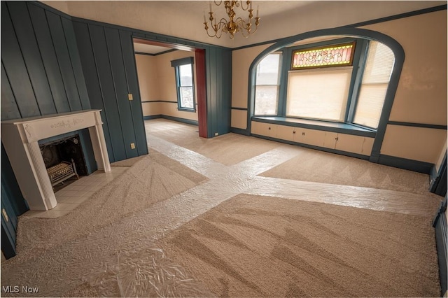 unfurnished living room with light colored carpet and an inviting chandelier