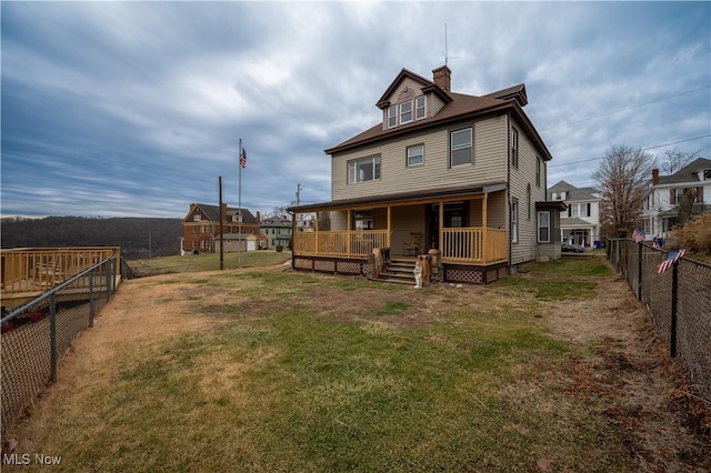 rear view of house featuring a lawn