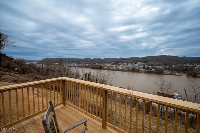 wooden deck with a water and mountain view