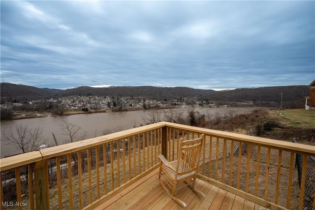 wooden terrace with a water and mountain view