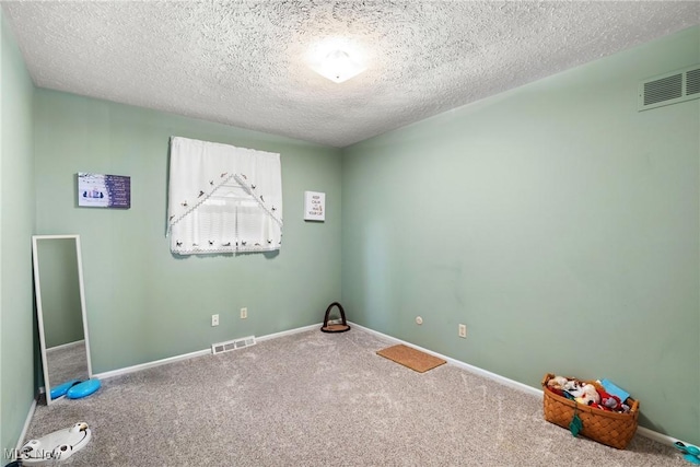 carpeted spare room with a textured ceiling