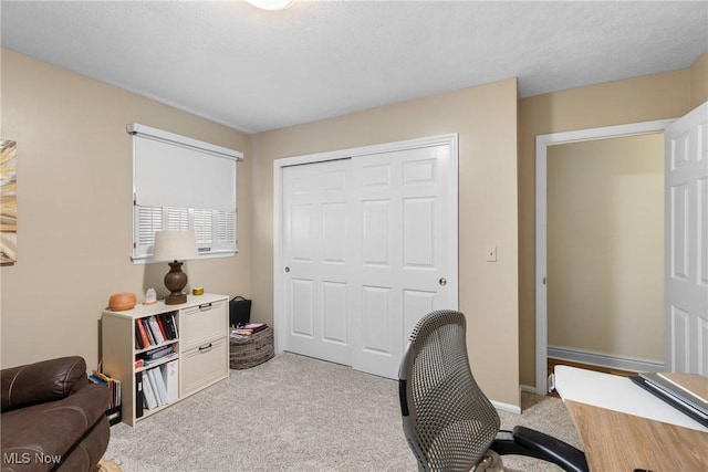 office space with light carpet and a textured ceiling