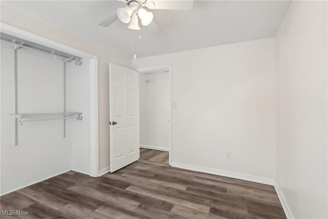 unfurnished bedroom featuring ceiling fan, dark wood-type flooring, a closet, and baseboards