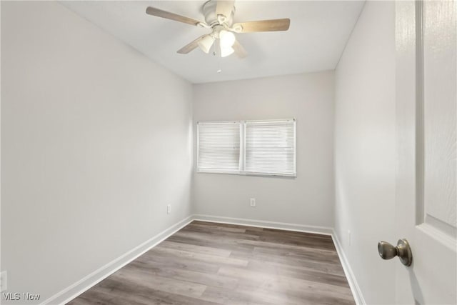 spare room featuring a ceiling fan, baseboards, and wood finished floors