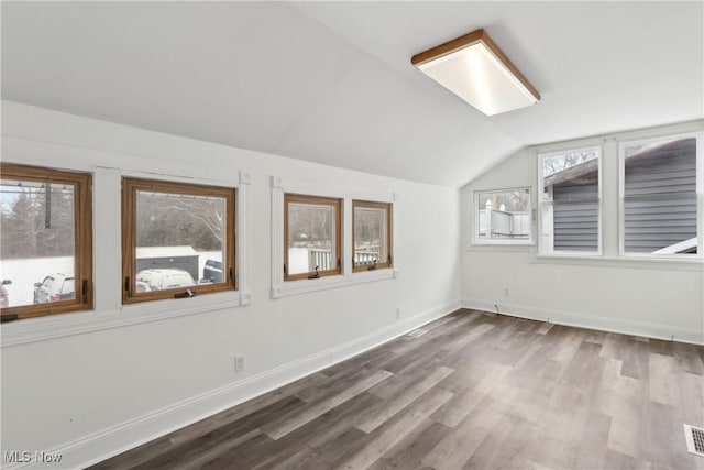 bonus room featuring lofted ceiling, plenty of natural light, visible vents, and wood finished floors