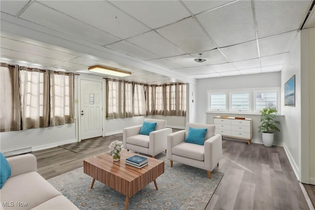 sunroom featuring a baseboard radiator and a drop ceiling