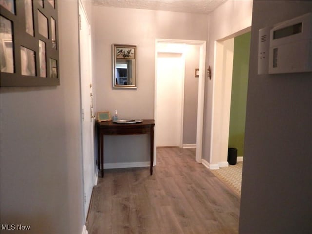 hall featuring hardwood / wood-style flooring and a textured ceiling