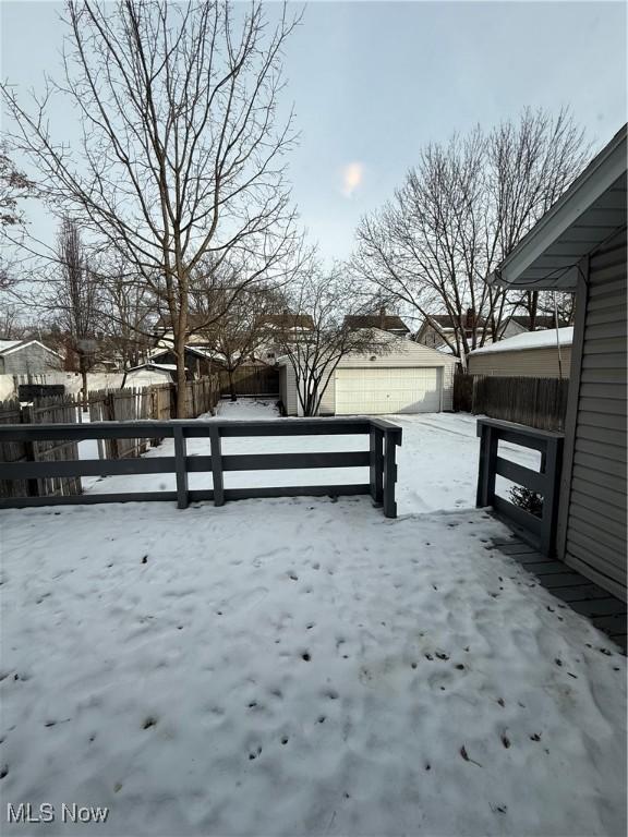 snow covered patio with an outdoor structure and fence