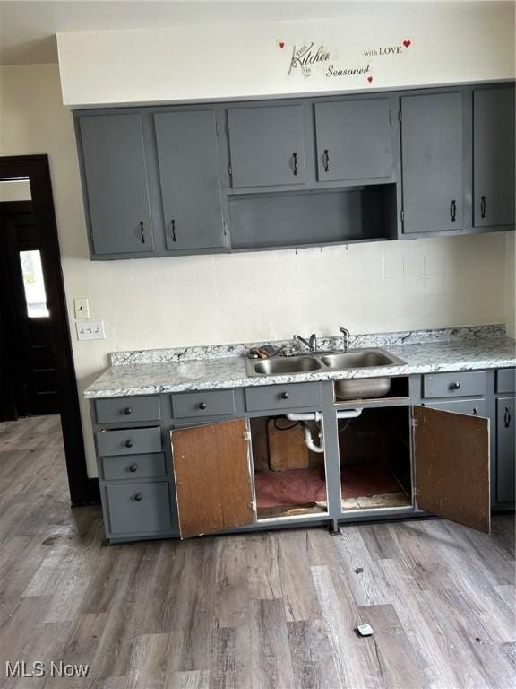 kitchen with gray cabinetry, sink, and hardwood / wood-style flooring