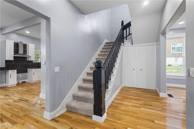 stairway featuring plenty of natural light and hardwood / wood-style floors