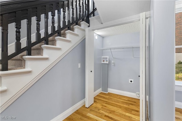 interior space with wood-type flooring, hookup for an electric dryer, and washer hookup