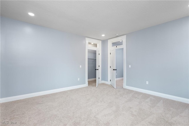 spare room featuring light carpet and a textured ceiling