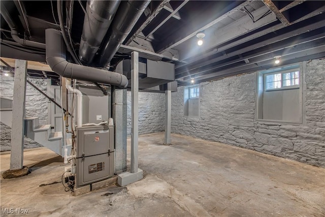 basement featuring heating unit and plenty of natural light