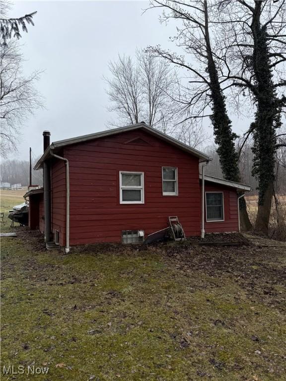 view of property exterior with a yard and central AC