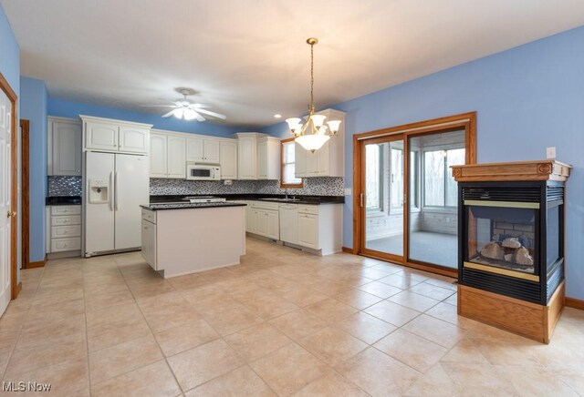 615 Crystal Brooke Dr, Hinckley, OH 44233 - kitchen featuring white appliances, a sink, dark countertops, decorative backsplash, and decorative light fixtures