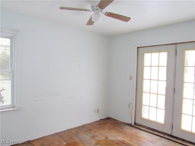 spare room with light wood-type flooring, ceiling fan, and a wealth of natural light