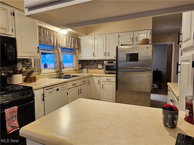 kitchen featuring white cabinets, sink, and black appliances