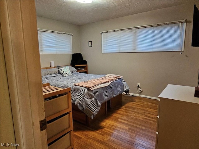 bedroom with hardwood / wood-style flooring and a textured ceiling