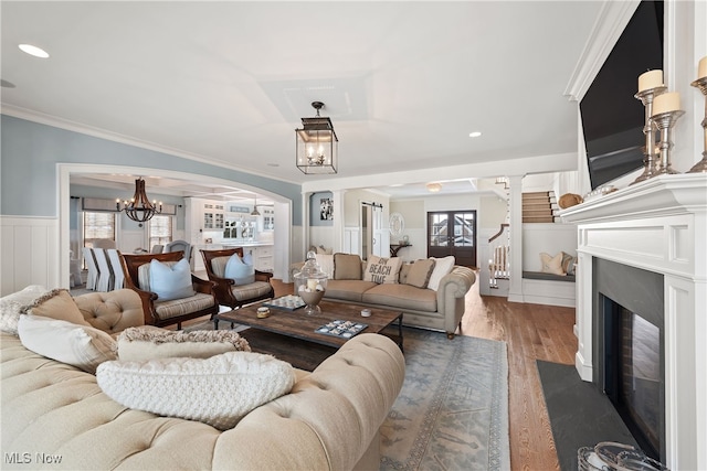 living room with crown molding, plenty of natural light, dark hardwood / wood-style flooring, and a chandelier