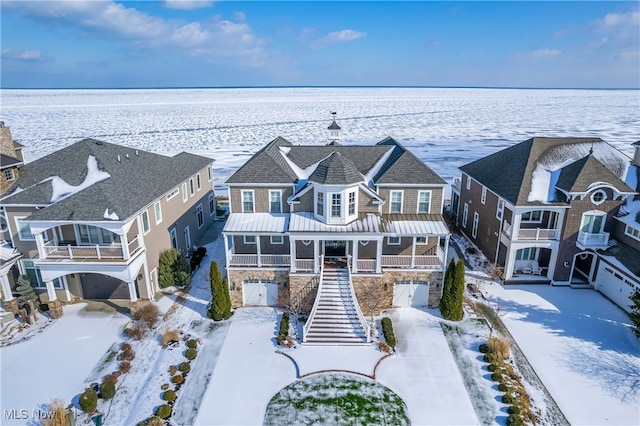 snowy aerial view with a water view