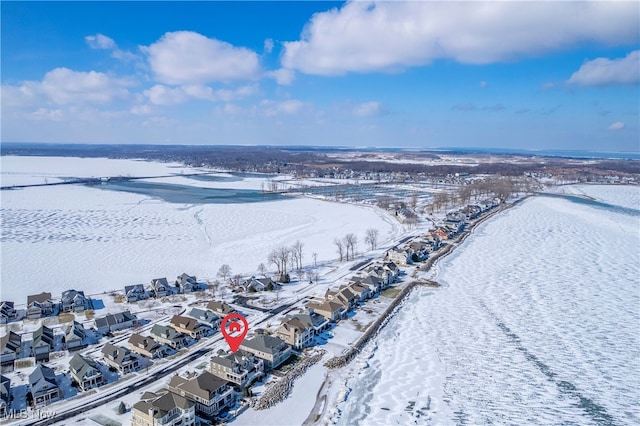 snowy aerial view featuring a water view