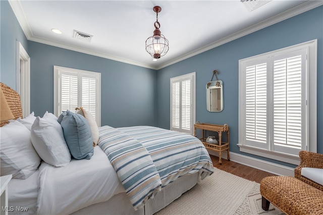 bedroom featuring crown molding, dark hardwood / wood-style flooring, and an inviting chandelier