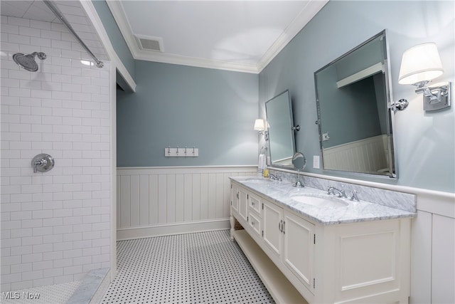 bathroom with crown molding, tiled shower, and vanity