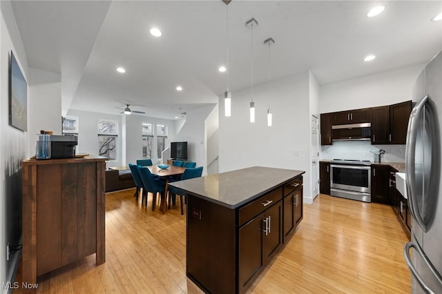 2280 City View Dr, Cleveland, OH 44113 - kitchen with light hardwood / wood-style flooring, decorative light fixtures, a kitchen island, and appliances with stainless steel finishes