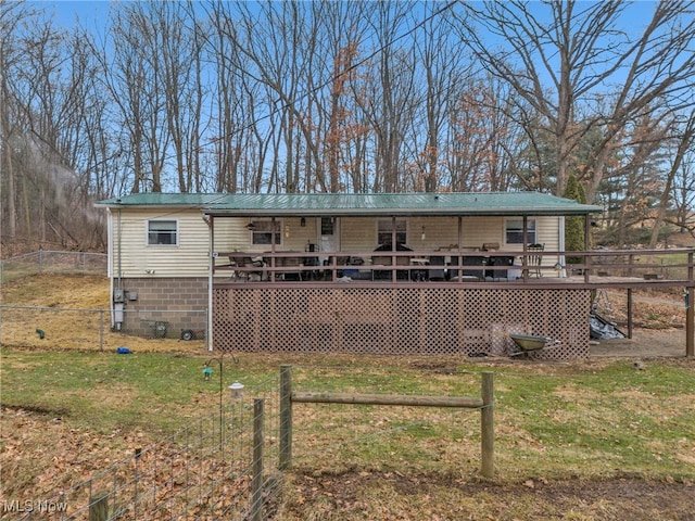 rear view of property featuring a wooden deck and a yard