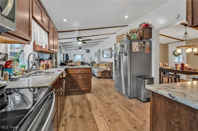 kitchen featuring appliances with stainless steel finishes, decorative light fixtures, sink, ceiling fan, and light hardwood / wood-style floors