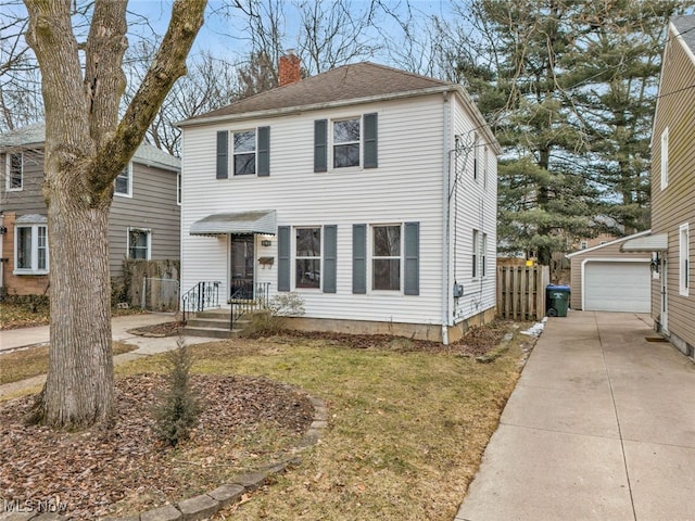 view of front of property with a garage, an outbuilding, and a front lawn