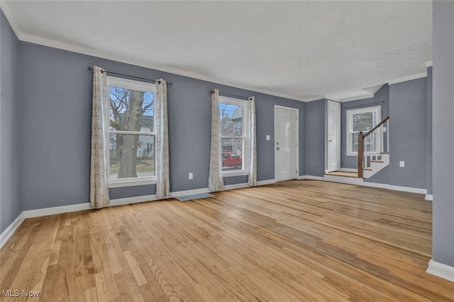 unfurnished living room with crown molding and light hardwood / wood-style flooring