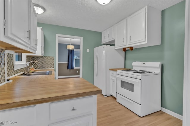 kitchen featuring sink, white cabinetry, white appliances, light hardwood / wood-style floors, and decorative backsplash