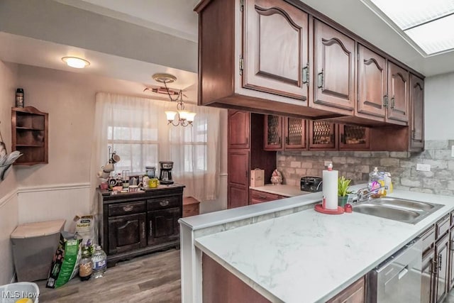 kitchen with sink, decorative backsplash, light hardwood / wood-style flooring, and a chandelier