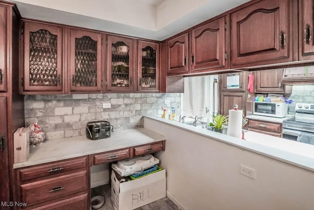 kitchen featuring backsplash, range hood, and electric range