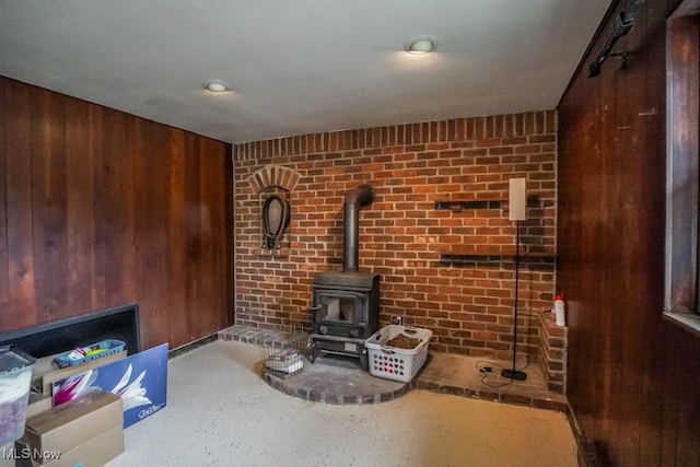 living room featuring wooden walls and a wood stove