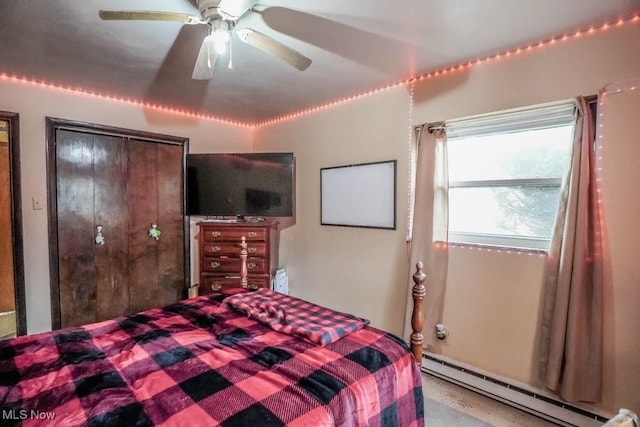 bedroom with ceiling fan and a baseboard heating unit